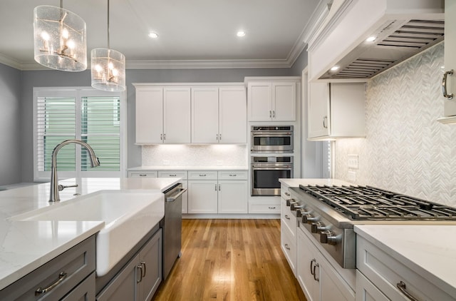 kitchen with a sink, decorative backsplash, stainless steel appliances, premium range hood, and gray cabinetry