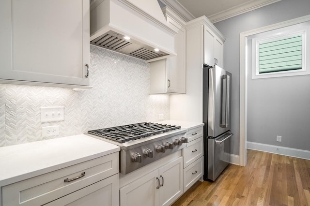 kitchen featuring crown molding, tasteful backsplash, stainless steel appliances, light countertops, and premium range hood