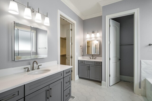 bathroom with tile patterned flooring, baseboards, a sink, and ornamental molding