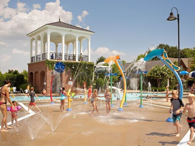 view of jungle gym featuring a water play area and a community pool