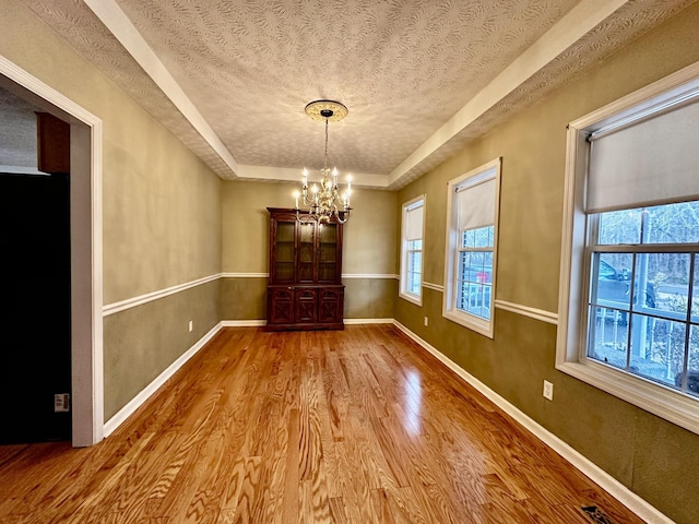273 Chapel Rd, New Johnsonville, TN 37134 - unfurnished dining area with an inviting chandelier, a textured ceiling, a raised ceiling, a wealth of natural light, and wood finished floors