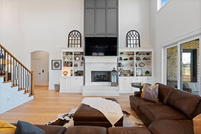 1428 Boardwalk Pl, Gallatin, TN 37066 - living room featuring arched walkways, a high ceiling, plenty of natural light, and light wood finished floors