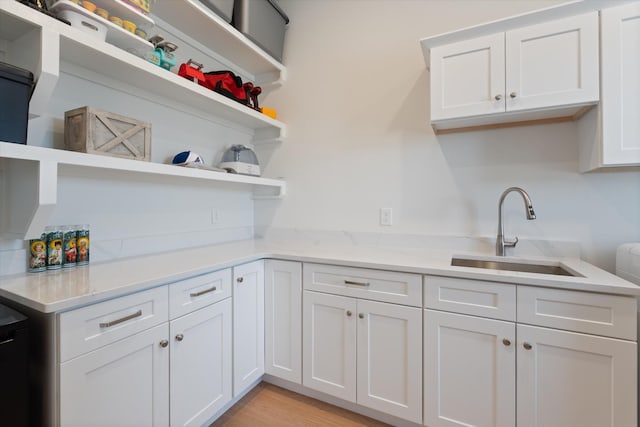 1428 Boardwalk Pl, Gallatin, TN 37066 - kitchen with a sink, open shelves, light wood finished floors, white cabinetry, and light stone countertops