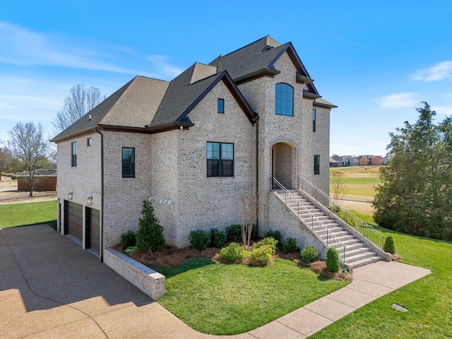 1428 Boardwalk Pl, Gallatin, TN 37066 - view of front facade with driveway, an attached garage, stairs, and a front yard