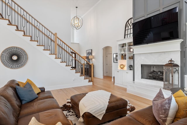 1428 Boardwalk Pl, Gallatin, TN 37066 - living room featuring light wood finished floors, stairs, a notable chandelier, and arched walkways
