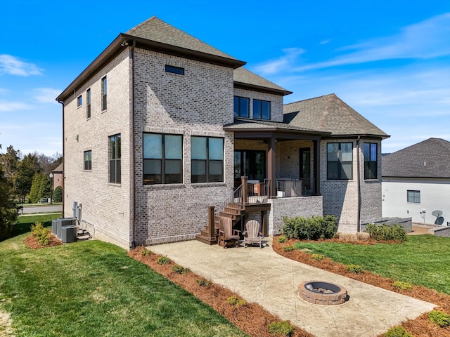 1428 Boardwalk Pl, Gallatin, TN 37066 - rear view of property with central air condition unit, an outdoor fire pit, brick siding, a lawn, and a patio area