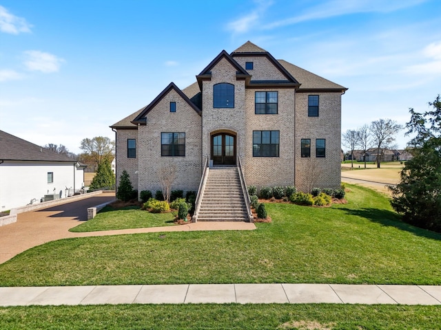 1428 Boardwalk Pl, Gallatin, TN 37066 - french country style house with stairs, a front lawn, french doors, and brick siding