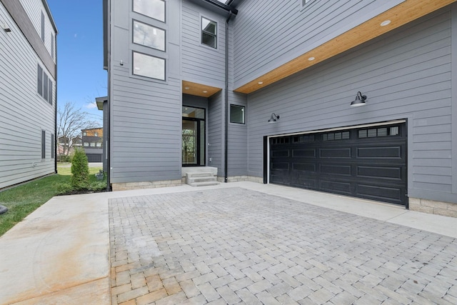 exterior space with a garage and decorative driveway