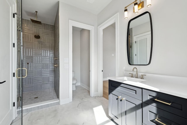 bathroom with baseboards, vanity, toilet, and a stall shower