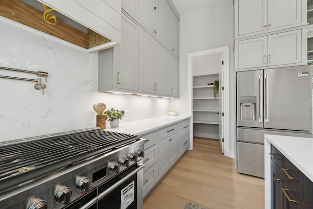 kitchen featuring light wood-type flooring, light countertops, and appliances with stainless steel finishes