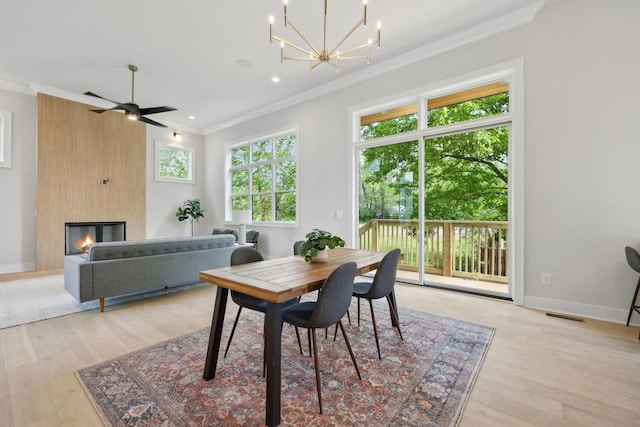 dining area with ornamental molding, light wood finished floors, and visible vents