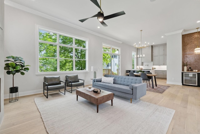 living area featuring wine cooler, recessed lighting, light wood-style floors, and ornamental molding