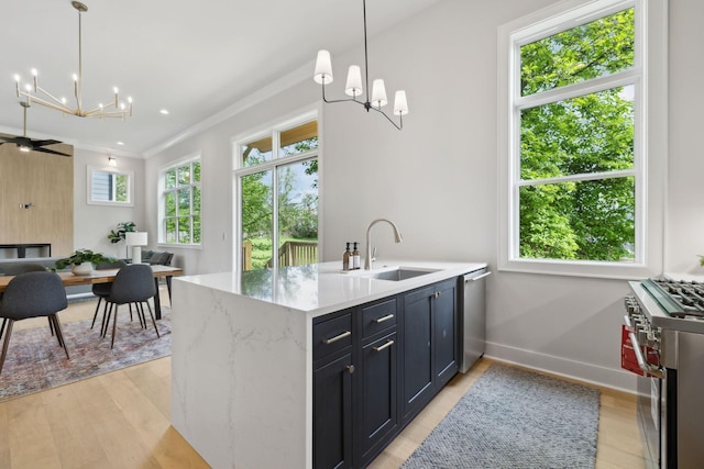kitchen featuring open floor plan, a sink, a notable chandelier, and appliances with stainless steel finishes