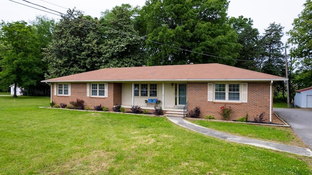 411 Whaley St, Smithville, TN 37166 - single story home with covered porch, brick siding, an outdoor structure, a front yard, and a garage