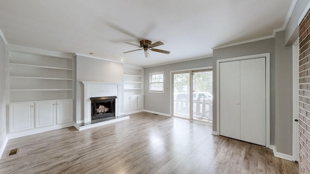 411 Whaley St, Smithville, TN 37166 - unfurnished living room featuring a fireplace with raised hearth, ceiling fan, wood finished floors, ornamental molding, and built in features
