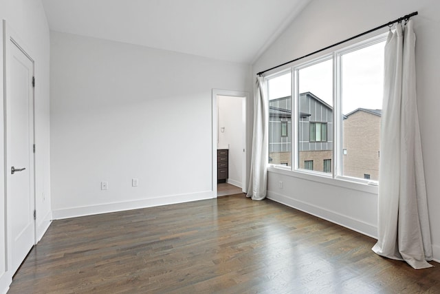 unfurnished bedroom featuring baseboards, wood finished floors, and vaulted ceiling