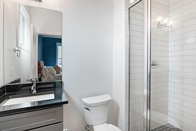 full bath featuring toilet, a stall shower, and vanity