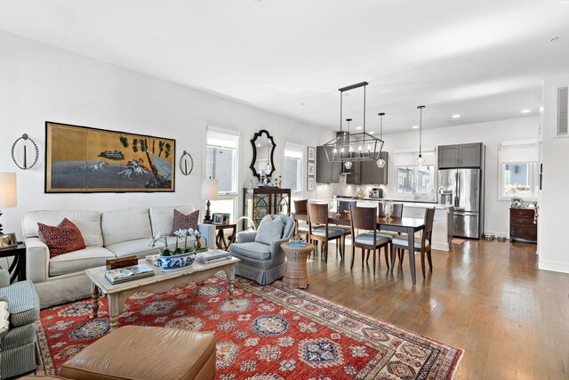 living room with dark wood-style floors, baseboards, a chandelier, and recessed lighting