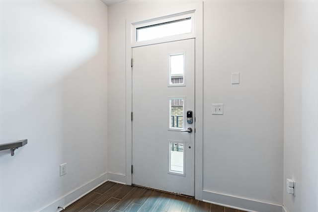 foyer entrance featuring baseboards and dark wood finished floors