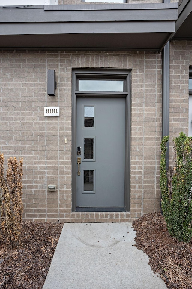 doorway to property with brick siding