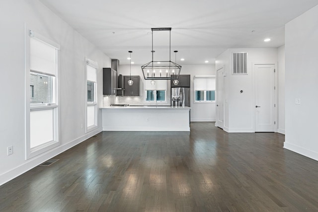 kitchen with dark wood-style floors, visible vents, light countertops, and stainless steel refrigerator with ice dispenser