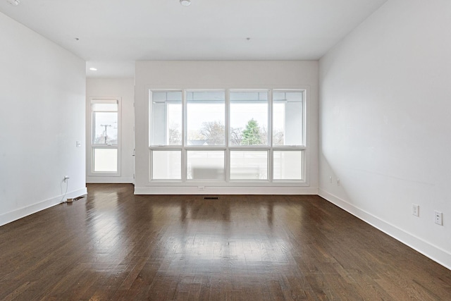 unfurnished room with dark wood-type flooring and baseboards