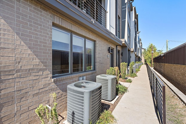 view of property exterior featuring central AC unit and brick siding