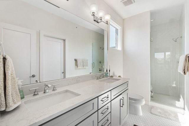 bathroom featuring a stall shower, visible vents, toilet, and a sink