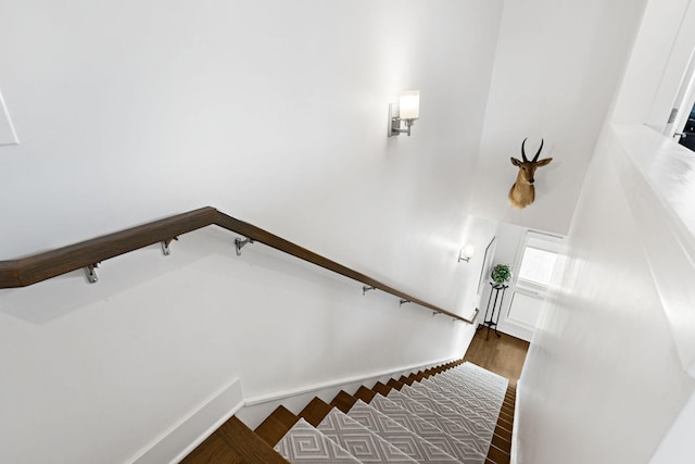 staircase with baseboards and wood finished floors