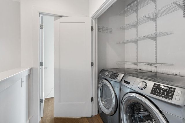 laundry room featuring washing machine and dryer, wood finished floors, and laundry area
