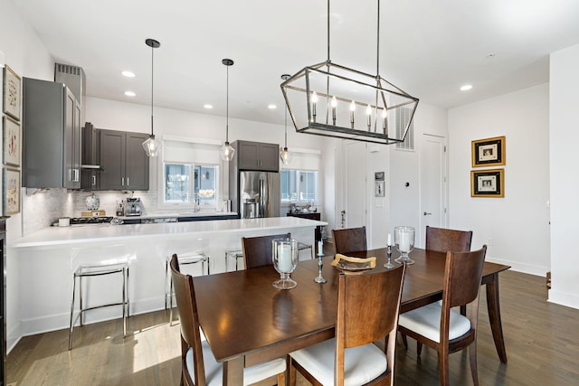dining room with dark wood-style floors, baseboards, and recessed lighting