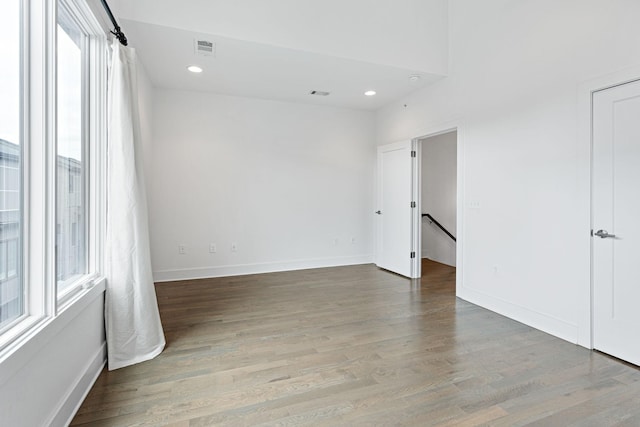 empty room with baseboards, visible vents, recessed lighting, and wood finished floors