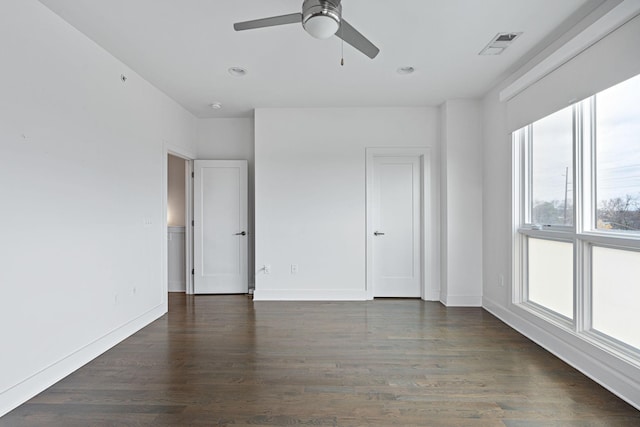 spare room featuring a ceiling fan, wood finished floors, baseboards, and visible vents