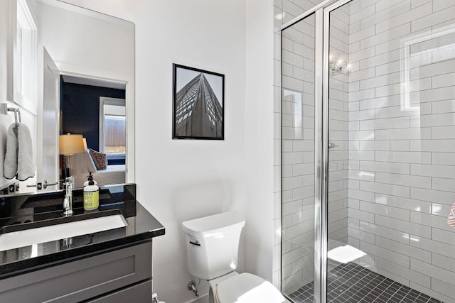 full bathroom featuring toilet, vanity, and a stall shower