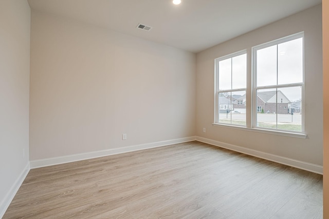 unfurnished room featuring light wood finished floors, baseboards, and recessed lighting