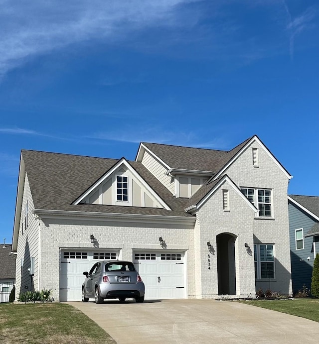 traditional-style home with concrete driveway, an attached garage, brick siding, and a shingled roof
