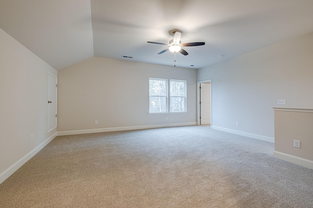 empty room with ceiling fan, light carpet, baseboards, and vaulted ceiling
