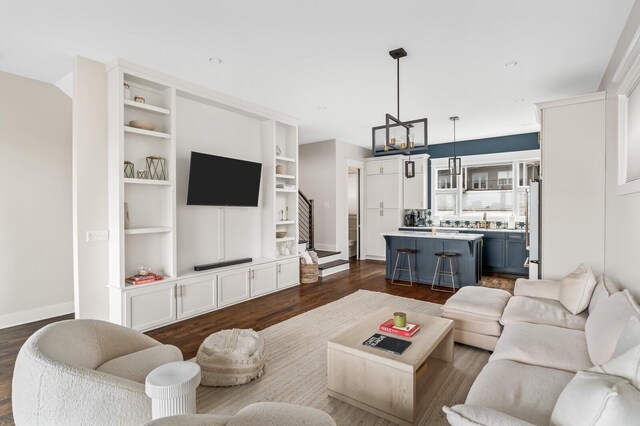 3118 Trevor St, Nashville, TN 37209 - living area featuring dark wood-style flooring, baseboards, an inviting chandelier, stairway, and built in shelves