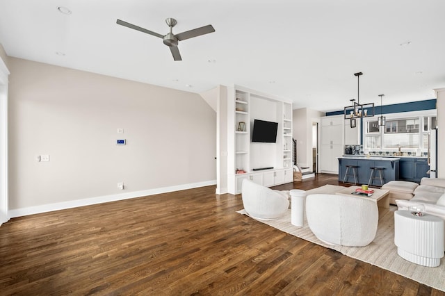 3118 Trevor St, Nashville, TN 37209 - living area featuring baseboards, dark wood-style floors, built in shelves, and ceiling fan with notable chandelier