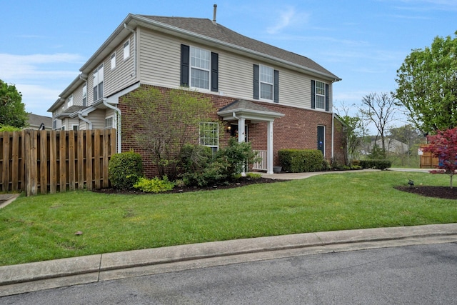 traditional-style home featuring fence, a front lawn, and brick siding