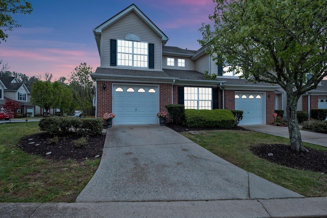 traditional-style house featuring roof with shingles, driveway, and brick siding
