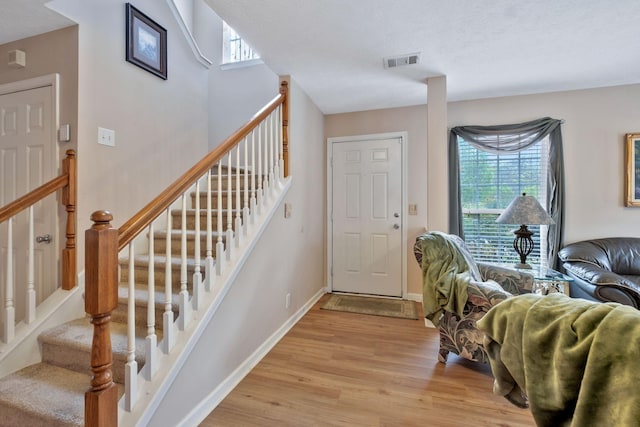 foyer with a healthy amount of sunlight, baseboards, light wood-style flooring, and visible vents
