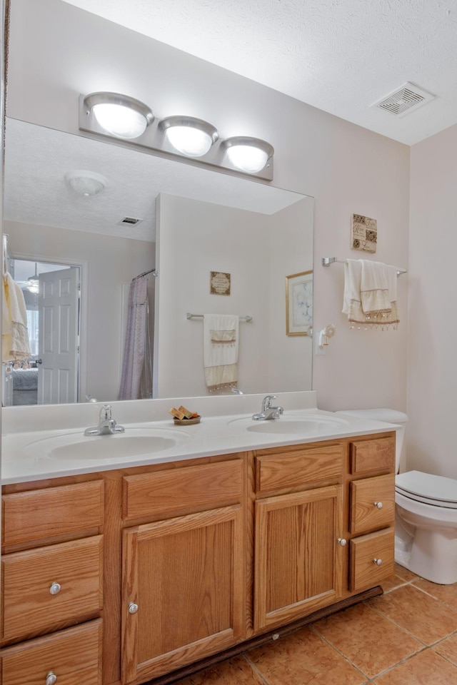 bathroom with a sink, tile patterned floors, toilet, and visible vents