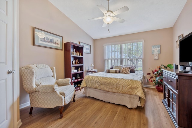 bedroom with baseboards, a ceiling fan, vaulted ceiling, and light wood-style flooring