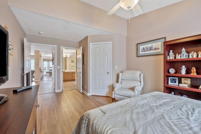 bedroom with baseboards, ensuite bathroom, and light wood-style floors