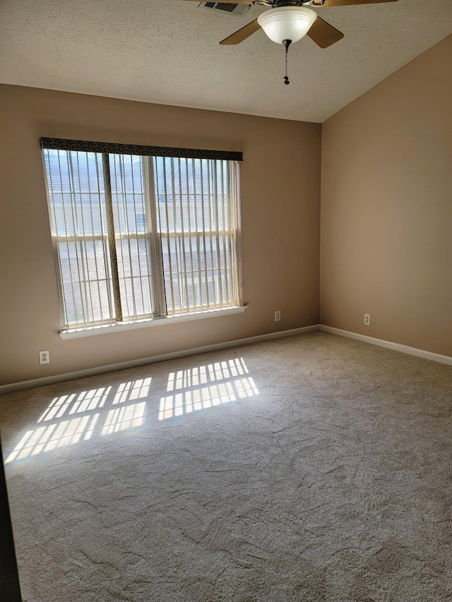 empty room with baseboards, plenty of natural light, carpet, and a ceiling fan