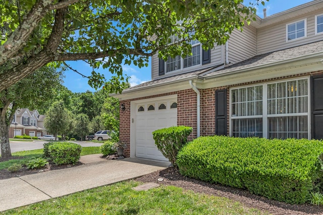 747 Tulip Grove Rd Unit 901, Hermitage, TN 37076 - view of side of home with brick siding, a garage, driveway, and a shingled roof
