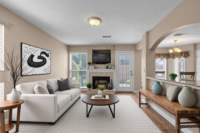 747 Tulip Grove Rd Unit 901, Hermitage, TN 37076 - living room with wood finished floors, arched walkways, a large fireplace, a chandelier, and baseboards