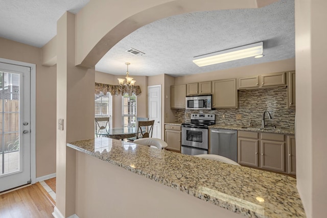 747 Tulip Grove Rd Unit 901, Hermitage, TN 37076 - kitchen with stainless steel appliances, a sink, backsplash, a textured ceiling, and light wood-type flooring