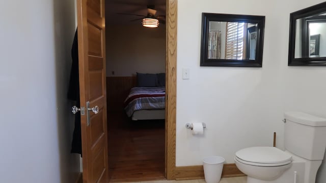 ensuite bathroom with wood finished floors, connected bathroom, ceiling fan, and toilet